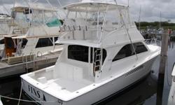 Vessel WalkthroughThe starboard side sliding salon doors open to reveal the interior of the 45 Convertible. The salon is set in a teak finish with warm colors and comfortable seating. There is a large L-shaped sofa to port galley forward to port and a